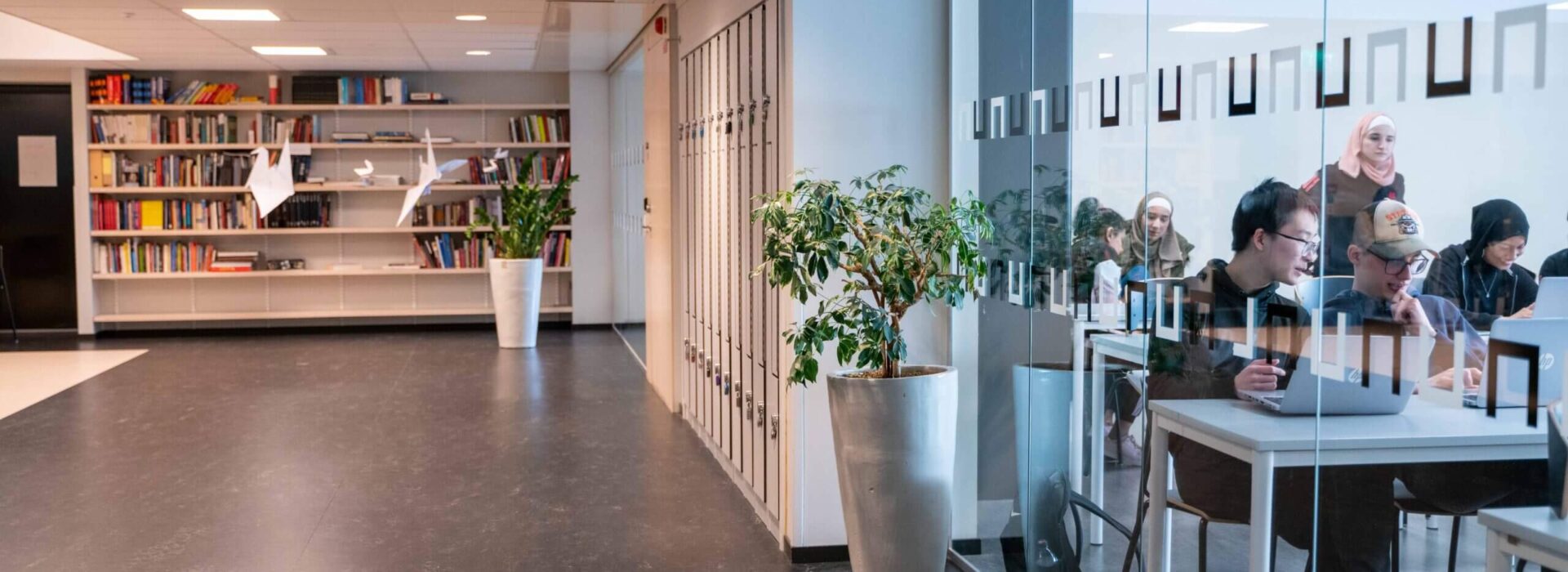 DSC05510 Korridor i skolan med glasvägg in till ett klassrum där elever jobbar på sina datorer