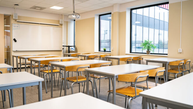 Tomt klassrum med bänkar och stolar