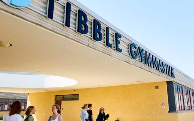 Entré till skola med elever som går in och ut från byggnaden