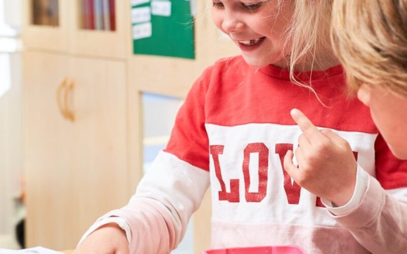 Flicka i rosa tröja som ritar